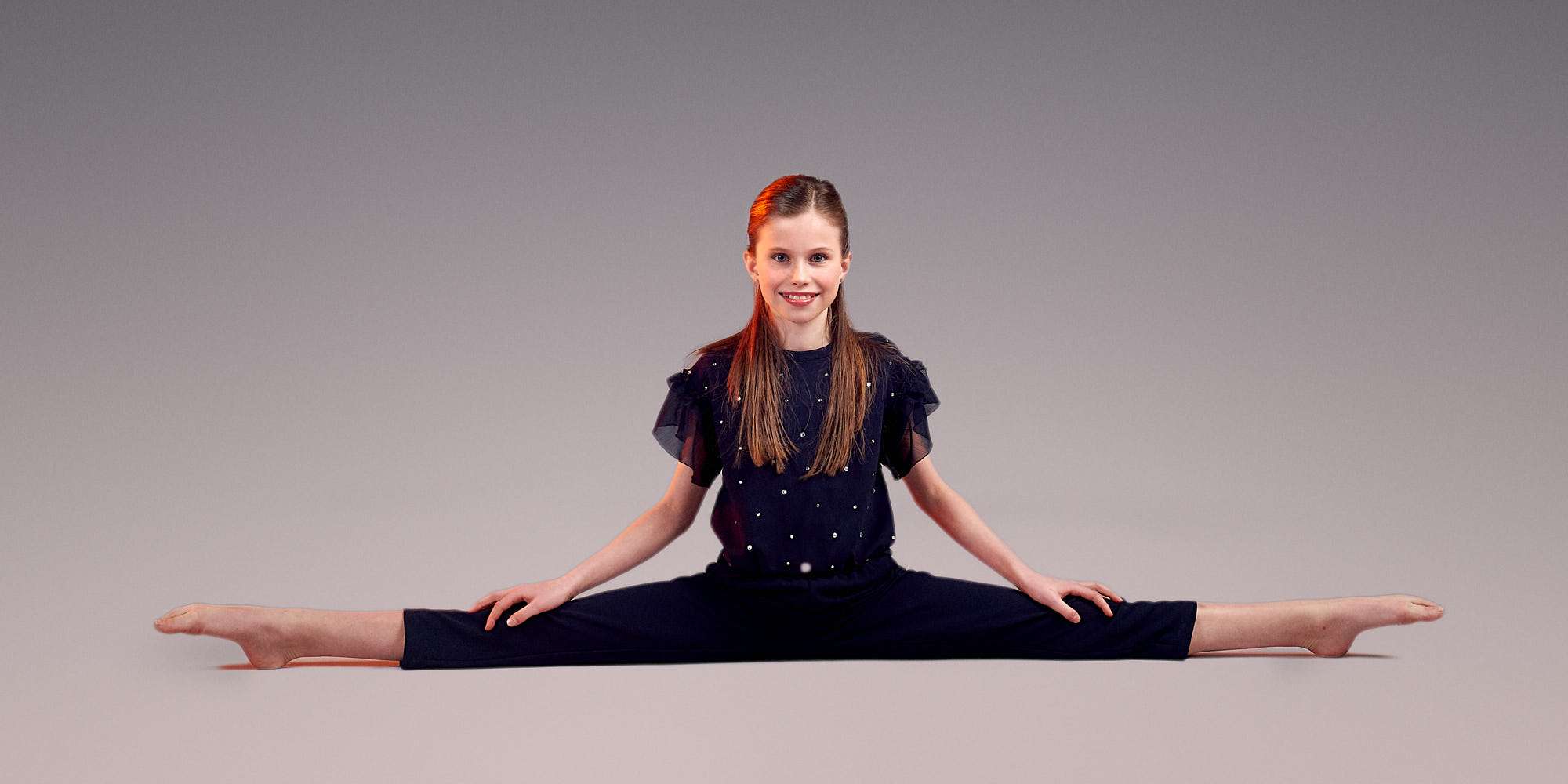 Girl posing in wide front split.