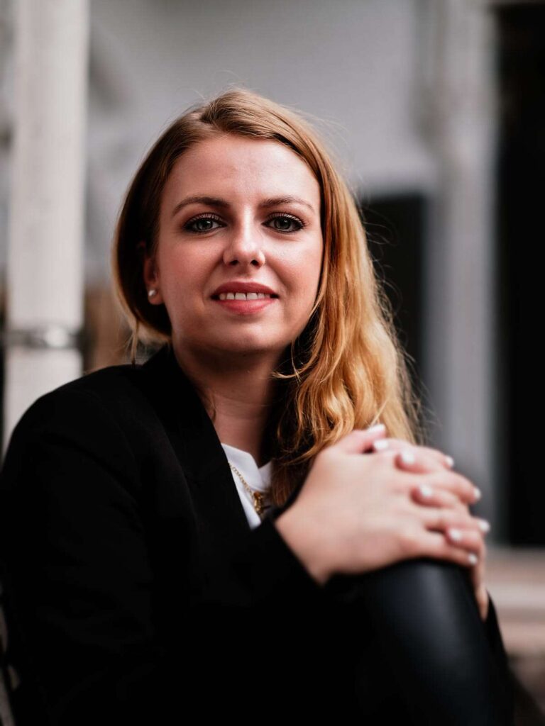 Portrait of a girl posing with her hands on one knee.