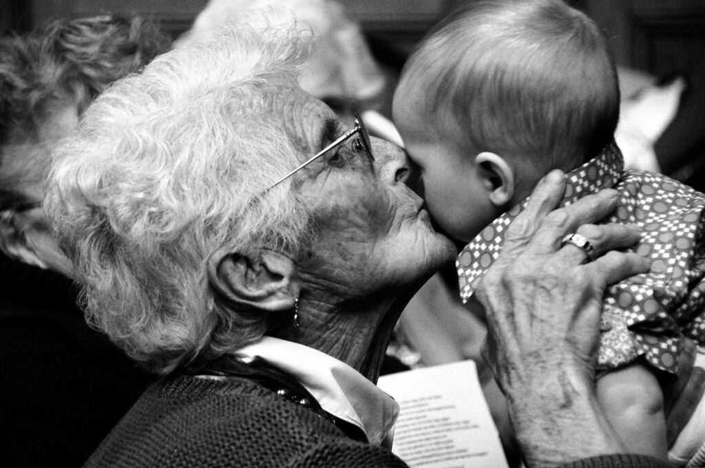 Grandmother kissing her grandson.