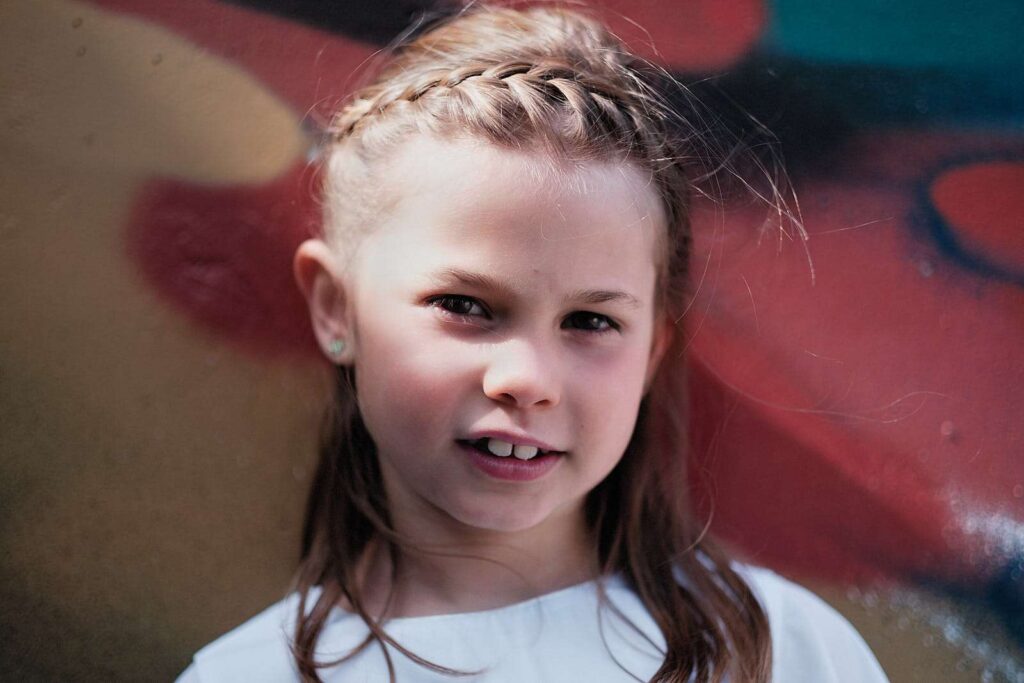 Headshot of a girl in front of a colorful wall.