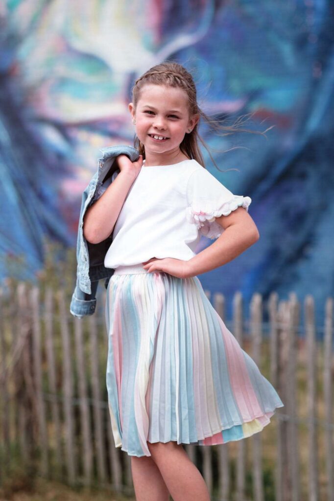 Girl posing with jacket on shoulder.