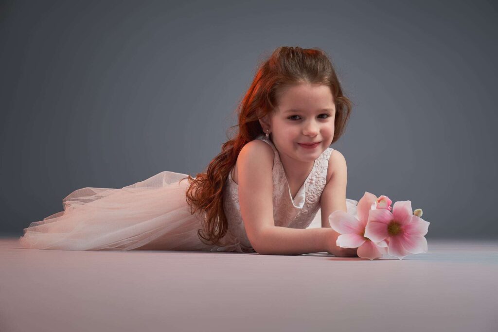 Portrait of a girl on her stomach leaning on her arms.