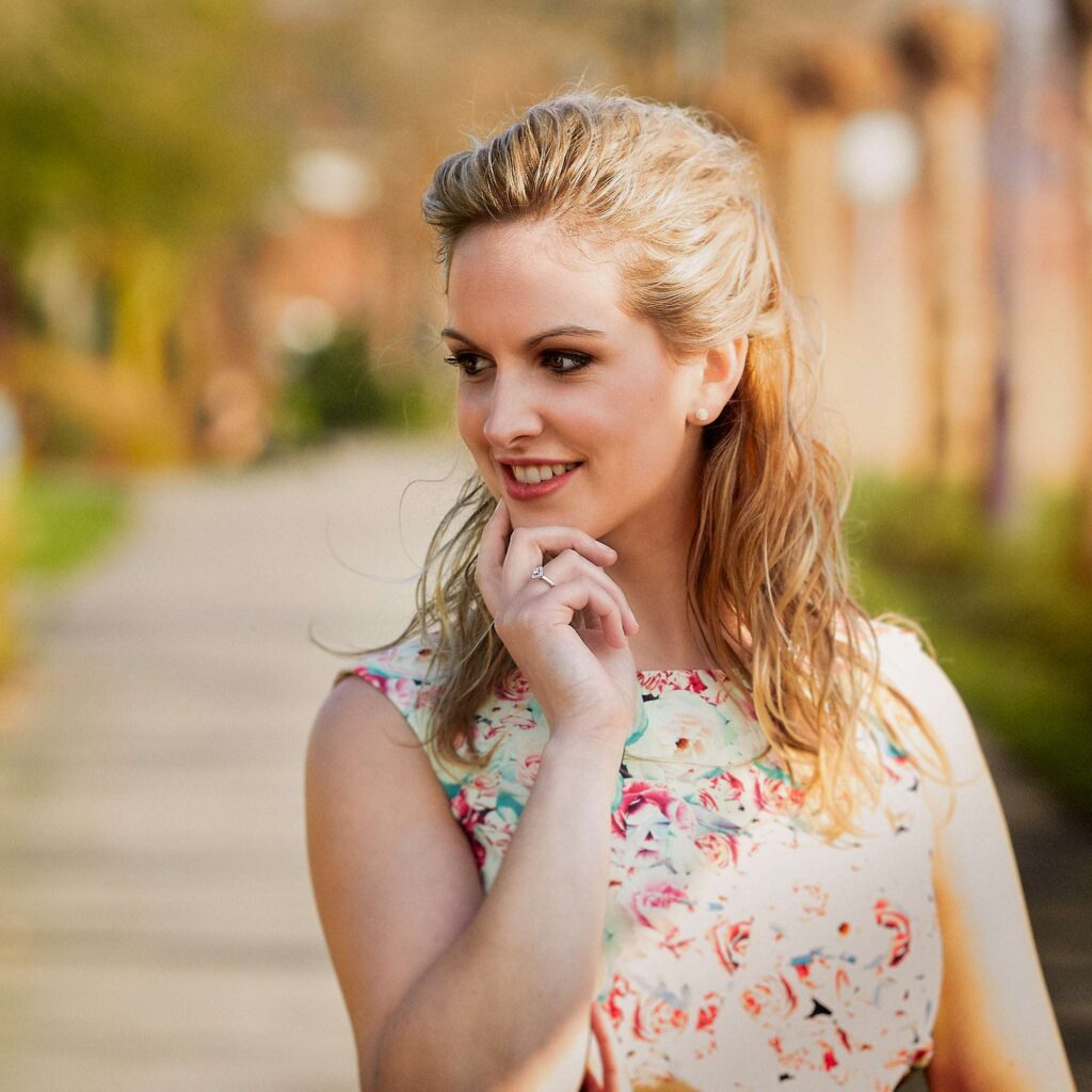 Woman posing with a finger on her chin.